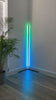 A video showing a programmed light show display in shades of green and blue on an Enlights LED vertical strip light on a V stand in the corner of a room. 